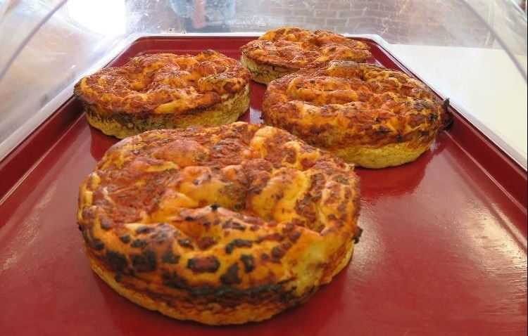 Four delicious looking pizzas ready for sale