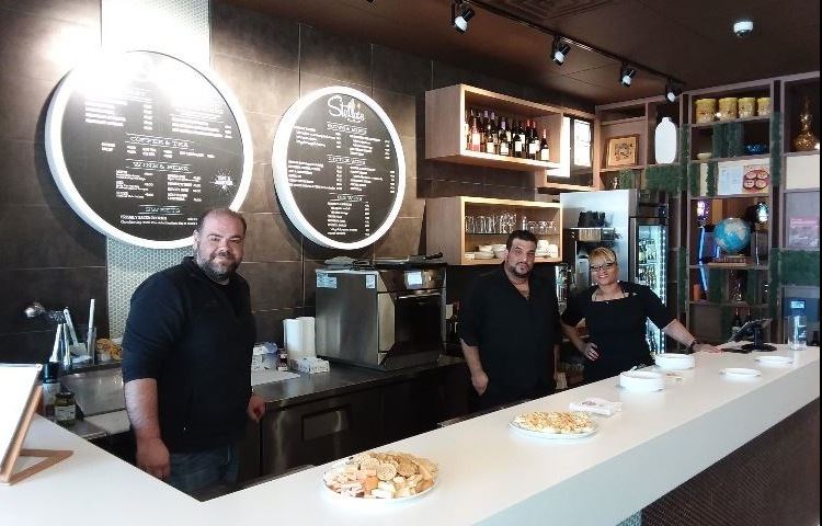 Three employees behind the counter ready to serve customers