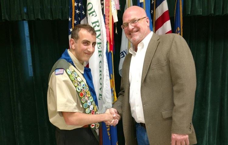 Village Trustee Bobby Thomas congratulating Shawn Guagenti on earning the rank of Eagle Scout